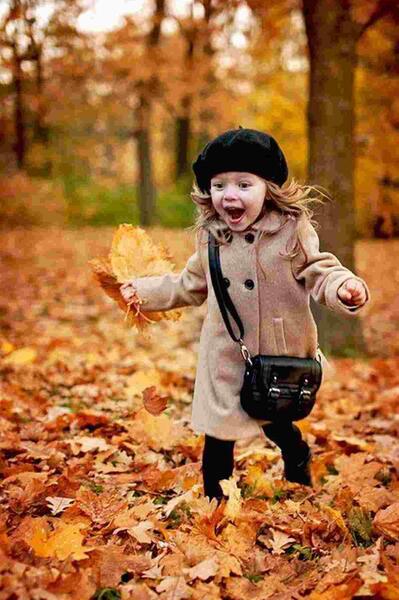 عکس دختر کوچولو زیبا با برگ های پاییز