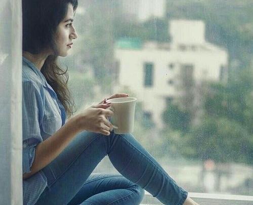 عکس دختر نشسته پشت پنجره