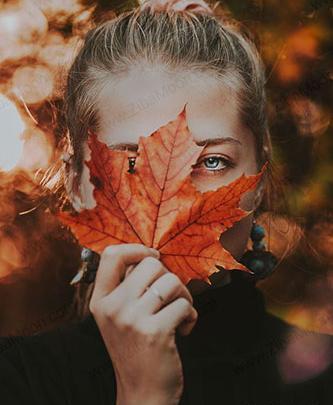 عکس برگ پاییز در دست دختر