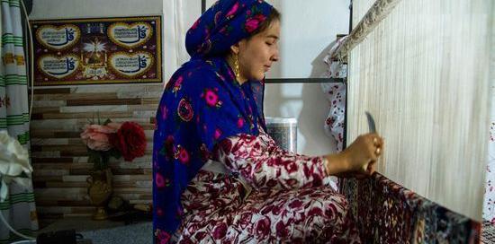 عکس دختر در حال قالی بافی