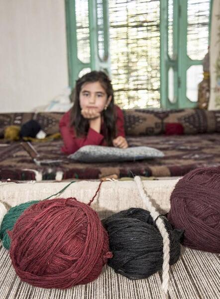 عکس دختر در حال قالی بافی