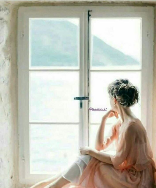 عکس دختری غمگین کنار پنجره